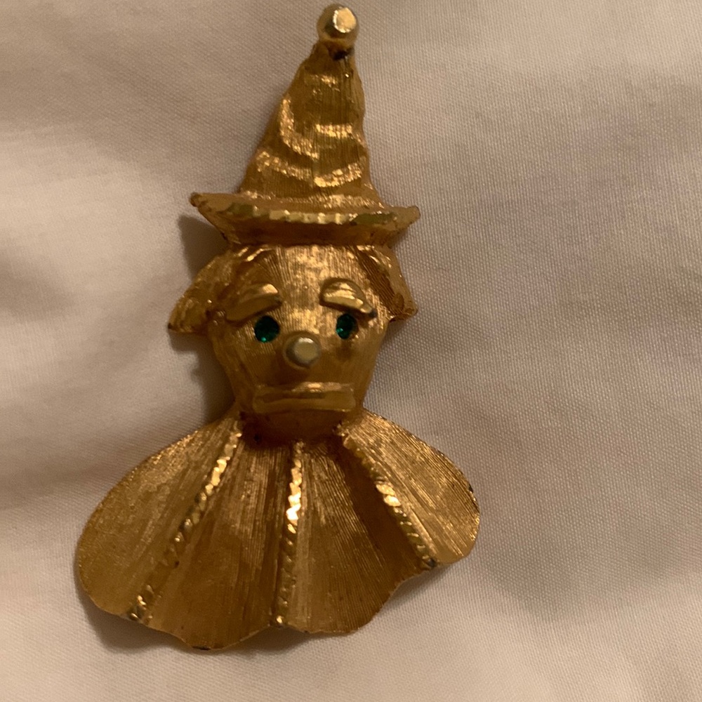 Vintage gold clown brooch with emerald eyes.